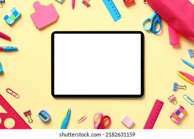 Back to school concept. Digital tablet mockup with blank screen and school supplies on yellow table. Flat lay, top view, copy space. - Powered by Shutterstock