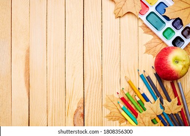 Back To School Concept. Education And Study Stationery On A Wooden Desk. Above View. Decorated With Yellow Maple Leaves.