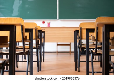 Back to School Concept. Empty classroom with chairs, desks and chalkboard.