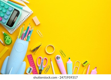 Back to school concept. Flat lay, top view colorful school supplies, rocket-shaped pencil case, calculator, notepad on yellow background. - Powered by Shutterstock