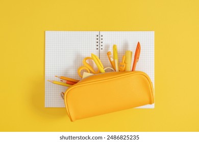 Back to school concept. Flat lay top view on full pencil case with pencils and pens with notebook isolated on yellow background with empty space for text - Powered by Shutterstock