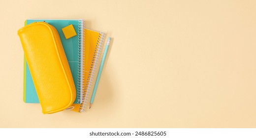 Back to school concept. Flat lay top view on stack of notebooks and pencil case with pens and pencils on beige background.  - Powered by Shutterstock