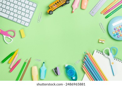 Back to school concept. Flat lay composition with Keyboard and school supplies on green background with copy space.