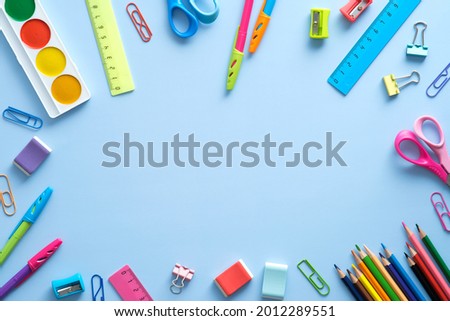 Back to school concept. Flat lay school stationery frame on a blue background. Top view, overhead.