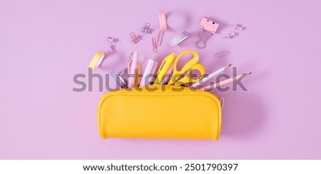 Back to school concept. Flat lay top view on full pencil case with pencils and pens with notepad isolated on pastel purple background. 