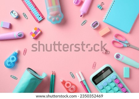 Back to school concept. Frame made of school supplies on pastel pink background.