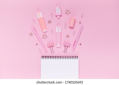 Back to school concept notepad, pencil case, stationery and school supplies. Top horizontal view copyspace pink abstract background