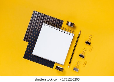 Back to school concept notepad, pencil case, stationery and school supplies. Top horizontal view copyspace yellow abstract background