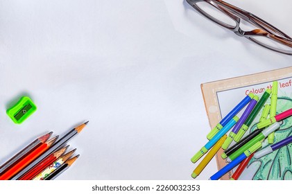 Back to school concept- a Pencil,erasor, sharpner an cut foil of the pencil on white table with or without spectacles not properly aranged isolated.