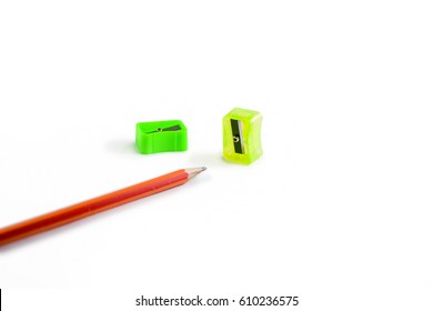 Back to school concept- a Pencil,erasor, sharpner an cut slice of the pencil on white table with or without spectacles not properly aranged isolated.