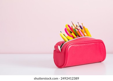 Back to school concept. Pink full pencil case with pencils and pens, scissors, school supplies isolated on against background of pink wall with empty space.  - Powered by Shutterstock