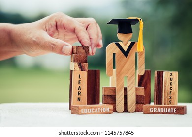 Back to School Concept, Student Sign wood with Graduation celebrating cap on wooden square blocks tower blur hands. Space for letter e.g education, graduate, learn. Ideas for international Educational