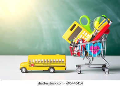 Back To School Concept. School Supplies, Schoolbus And Shopping Cart With Stuff