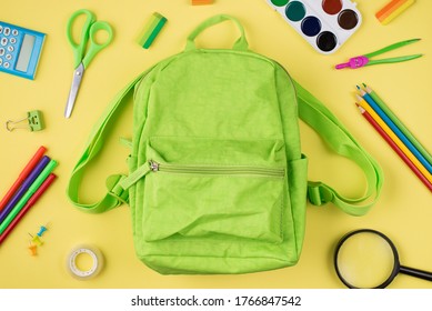 Back To School Concept. Top Above Overhead View Photo Of Green Backpack And Colorful Stationery Isolated On Yellow Background