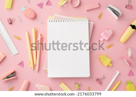 Back to school concept. Top view photo of notepads pens ice cream shaped sharpeners ruler staplers clips adhesive tape markers and pineapple shaped erasers on isolated pink background with copyspace