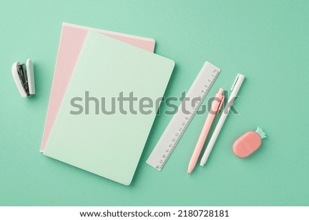 Back to school concept. Top view photo of stationery copybooks pens ruler stapler and pineapple shaped eraser on isolated pastel green background