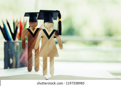 Back to School Concept, Two People Sign wood with Graduation celebrating cap on open textbook show alternative studying. Graduate or Education knowledge learning study abroad international Ideas.