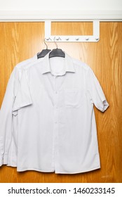 Back to school concept, school uniform such as white shirts hanging on the door - Shutterstock ID 1460233145