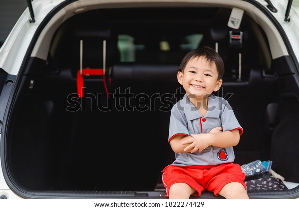 Back to School Concept.Happy Funny smiley\
face little asian boy wearing school uniform very excited and glad\
when he go back to school in car.Student toddler Child from\
elementary school\
kindergarten.