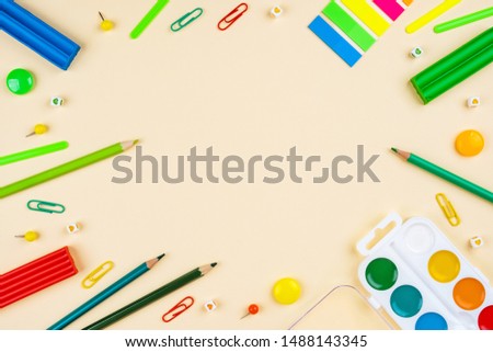 Back to school creative template with pencils, clips and watercolor. Composition in green colors.
