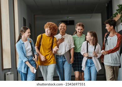 back to school, cultural diversity, teacher and teenage students walking in school hallway, smile - Powered by Shutterstock