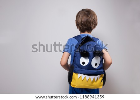 Back to school during Covid19 pandemic, young boy with monster face backpack