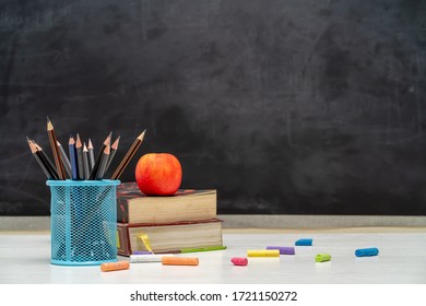 Back To School And Education Concept. Books With Pencil Holder On White Table. Blackboard In Background. 