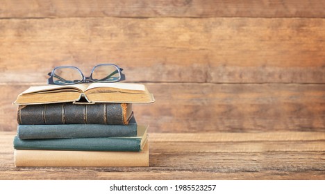 Back to school and education concept. Books and glasses on the open book on a wooden background and place for text.	 - Powered by Shutterstock