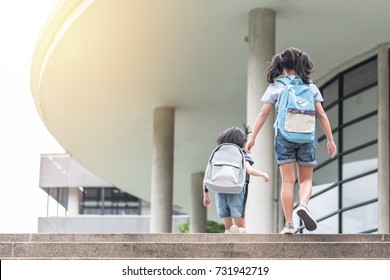 Back To School Education Concept With Girl Kids (elementary Students) Carrying Backpacks Going, Running To Class On School First Day And Walking Up Building Stair Happily