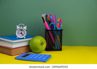 Back to school and education concept. Red alarm clock, apple, color pencils, books on a blue background. Learning for all - Powered by Shutterstock