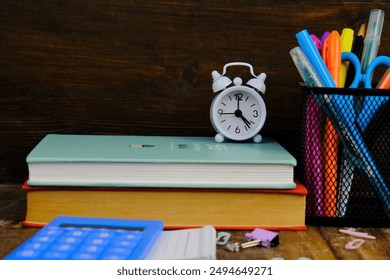 Back to school and education concept. Red alarm clock, apple, color pencils, books on a blue background. Learning for all - Powered by Shutterstock