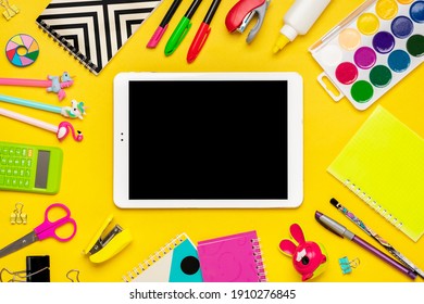 Back to school, education concept.  School supplies Notebook, pens, ruler, calculator, scissors, tablet isolated on yellow background Top view Copy space Flat lay composition Mock up