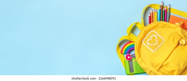 Back to school, education concept Yellow backpack with school supplies - notebook, pens, eraser rainbow, numbers isolated on blue background Top view Copy space Flat lay composition Banner - Shutterstock ID 2166948591