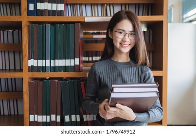 Back To School Education Knowledge College University Concept, Beautiful Female College Student Holding Her Books Smiling Happily Standing In Library, Learning And Education Concept
