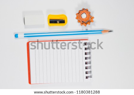 Back to school and education minimal concept with pencil, eraser, sharpner, notebook and wooden pencil shavings on a white background