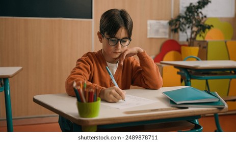 Back to school elementary primary education studying Caucasian boy little son guy schoolboy kid child pupil student schoolboy at class lesson study learning writing task math write pen exam learn - Powered by Shutterstock