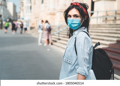 Back To School. Female Student Wearing Protective Face Mask Looking At Camera While Walking Around University Campus During COVID 19. Education, Healthcare And Pandemic Concept