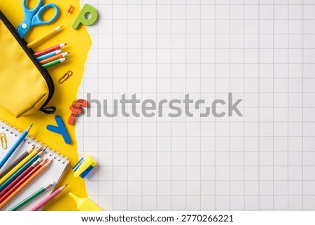 Back to school flat lay featuring colorful stationery, a pencil case, colored pencils and notebook arranged on grid paper, ideal for education, study and creative classroom projects