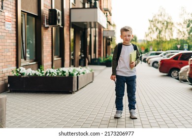 Back To School. Funny Child With Backpack Holding Notepad And Training Books Going To School. Boy Pupil With Bag. Elementary School Student Going To Classes. Kid Walking Outdoor On The City Street.