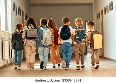 Back to school. A group of schoolchildren with backpacks walk along the school corridor during recess. Education and science concept. - Powered by Shutterstock