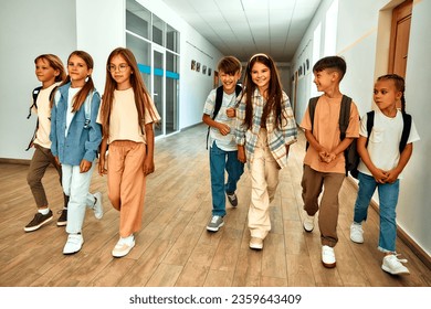 Back to school. A group of schoolchildren with backpacks walk along the school corridor during recess. Education and science concept. - Powered by Shutterstock