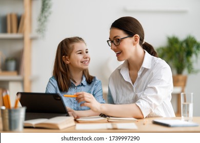 Back To School. Happy Child And Adult Are Sitting At Desk. Girl Doing Homework Or Online Education.