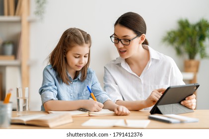 Back To School. Happy Child And Adult Are Sitting At Desk. Girl Doing Homework Or Online Education.