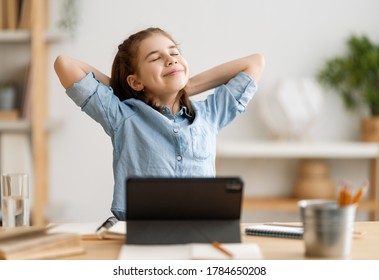 Back To School. Happy Child Is Sitting At Desk. Girl Doing Homework Or Online Education.