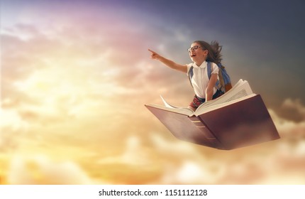 Back to school! Happy cute industrious child flying on the book on background of sunset sky. Concept of education and reading. The development of the imagination. - Shutterstock ID 1151112128