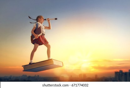 Back To School! Happy Cute Industrious Child Flying On The Book On Background Of Sunset Urban Landscape. Concept Of Education And Reading. The Development Of The Imagination.