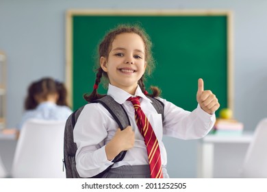 Back to school. Happy schoolgirl raised her finger up smiling on the background of the school blackboard in the classroom. Learning education lecture development of children of students at school - Powered by Shutterstock