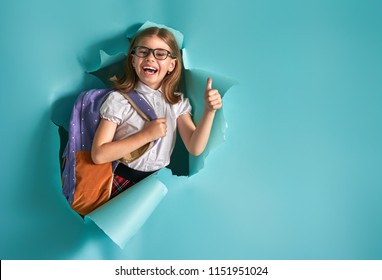 Back To School And Happy Time! Cute Industrious Child Is Breaking Through Color Paper Wall. Kid With Backpack. Girl Ready To Study.