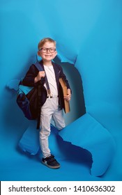 Back To School. Industrious Child Boy With Backpack And Books. Happy Kid Is Breaking Paper Wall. 