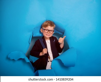 Back To School. Industrious Child Boy With Backpack And Books. Happy Kid Is Breaking Paper Wall. 